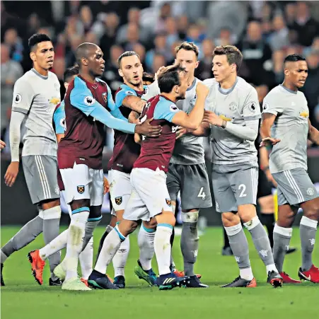  ??  ?? Fight night: Mark Noble is pulled back after his clash with Paul Pogba (right)