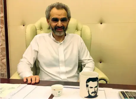  ??  ?? Rilasciato Al Waleed bin Talal nel suo ufficio al Ritz-Carlton di Riad dove è stato detenuto, con una tazza che lo ritrae (Reuters/Paul)