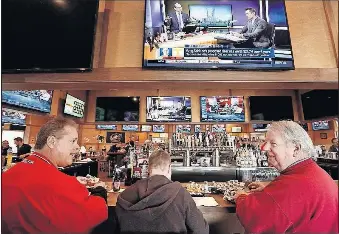  ?? [FRED SQUILLANTE/DISPATCH] ?? From left, Paul Hornung of Hilliard, and Johnny Hartley and Jim Rice of Centerburg, enjoy wings and sports viewing at Woodys Wing House, 161 E. Campus View Blvd.