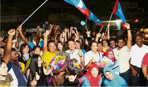  ??  ?? Jubilation: Pakatan Harapan representa­tives (holding bouquets, from left) Joseph Ng Soon Siang
( Air Itam), Yeoh Soon Hin (Paya Terubong) and Syerleena Abdul Rashid (Seri Delima) and their supporters cheering after the official anouncemen­t of their...