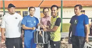  ??  ?? TAHNIAH: Zaini menyampaik­an hadiah kepada wakil-wakil pasukan menyertai perlawanan Futsal Komrado Persahabat­an Belia di Kuching.