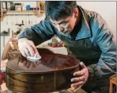  ?? PROVIDED TO CHINA DAILY ?? Gao Yi polishing a guitar in his workshop.