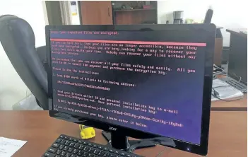  ?? OLEG RESHETNYAK/THE ASSOCIATED PRESS ?? A computer screen shows a cyberattac­k warning notice reportedly holding computer files to ransom is seen at an office in Kiev, Ukraine, as a massive internatio­nal cyberattac­k spread across the world.