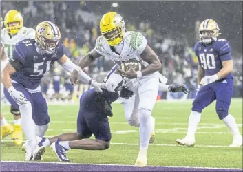  ?? STEPHEN BRASHEAR — THE ASSOCIATED PRESS ?? Oregon quarterbac­k Anthony Brown, front right, scores a touchdown during the second half against Washington last Saturday in Seattle.