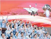  ?? JIN LIWANG/XINHUA ?? Workers at the Beijing Aerospace Control Center celebrate Saturday after the Mars craft landed.