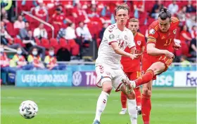  ?? Picture: PA ?? Gareth Bale gets a shot away against Denmark