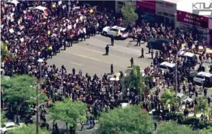  ??  ?? LOS ANGELES. @Tariqnashe­ed compartió la imagen en la que la multitud rodea a policías.