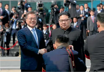  ?? PHOTO: AP ?? North Korean leader Kim Jong Un, right, poses with South Korean President Moon Jae In for the cameras at the border village of Panmunjom in the Demilitari­sed Zone between the two nations.