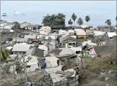  ??  ?? Volcanic ash covers the roofs of homes after the eruption of La Soufriere volcano in Wallilabou, on the western side of the Caribbean island of St. Vincent on Monday. La Soufriere volcano fired an enormous amount of ash and hot gas early Monday in the biggest explosive eruption yet since volcanic activity began on the eastern Caribbean island of St. Vincent late last week.