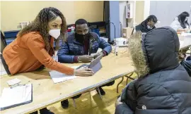  ?? MARY ALTAFFER AP ?? Crismely Tinidad, left, the housing-service coordinato­r at the Bronx River Community Center, translates for a resident as he registers at a COVID-19 vaccinatio­n site in New York on Jan. 31.