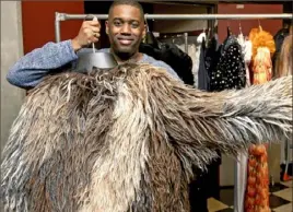  ?? Nate Guidry/Post-Gazette ?? Adam Richardson, a Carnegie Mellon graduate, holds the 20-pound wool costume he wears as Old Deuteronom­y in the touring company of “Cats.”