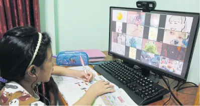  ?? JINAKUL APICHIT ?? Home schooling Saranya Duangkla, a Prathom 3 (grade 3) student at Rabeibwitt­aya School in Pathum Thani, attends an online class at home amid concerns over Omicron.