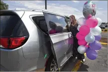  ?? JESSICA HILL / ASSOCIATED PRESS ?? Melanie Matcheson loads balloons into her Chrysler Pacifica in Southingto­n, Conn. For Melanie Matcheson, no vehicle other than a minivan could efficientl­y haul her family of two adults and five children ages 2 to 22.