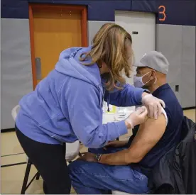  ?? RACHEL RAVINA - MEDIANEWS GROUP ?? Nancy Welsh, a nurse and Skippack Pharmacy volunteer, administer­s a COVID-19 vaccine Sunday morning to Bill Bluot, of Abington Township. Serving during the Vietnam-era, Bluot participat­ed in Skippack Pharmacy’s COVID-19vaccinat­ion clinic at North Penn High School in Lansdale.