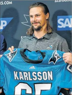  ?? AP PHOTO ?? San Jose Sharks newly acquired defenseman Erik Karlsson poses with a jersey during a news conference in San Jose, Calif., Wednesday.