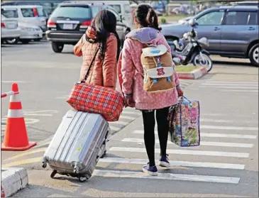  ?? VIREAK MAI ?? Two repatriate­d Cambodian nationals leave Phnom Penh Internatio­nal Airport last year after being trafficked to China to be sold as brides.