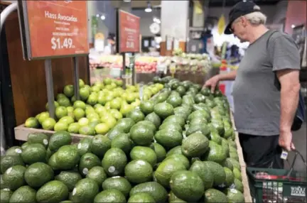  ?? THE ASSOCIATED PRESS ?? A man shops for avocados at a Whole Foods Market on Monday in New York. Amazon is moving swiftly to make big changes at Whole Foods, saying it plans to cut prices on avocados, bananas, eggs, salmon, beef and more. Amazon has completed its $13.7 billion...