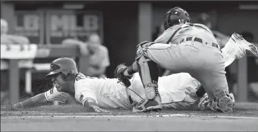  ?? JOHN SLEEZER/TRIBUNE NEWS SERVICE ?? The Royals' Salvador Perez scores under the tag of Detroit Tigers catcher James McCann on a groundout by Alcides Escobar in Kansas City, Mo., on Thursday.