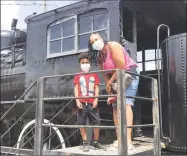  ?? Tom McCullough / Danbury Railway Museum / Contribute­d photos ?? Danbury residents Tamara Harrell and her son, Liam, enjoy the 1907 Boston & Maine Railroad steam locomotive outside the Danbury Railway Museum.