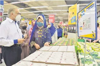  ?? — Photo by Roystein Emmor ?? (From left ) Dr Ameer accompanie­s Fatimah during her tour at Mydin Petra Jaya hypermarke­t.