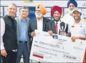  ?? HT PHOTO ?? Chikkarang­appa S (R) is handed the winner’s cheque by Milkha Singh and Jeev Milkha Singh (L) in Chandigarh on Sunday.