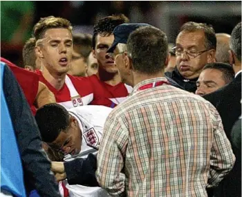  ??  ?? Chaos: Tom Ince (white shirt) is hit by a stone on Tuesday