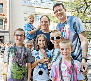  ?? NICOLE GIFFORD BAUGH/AP ?? Kevin Neubert, back center, and Jim Gorey attend the Chicago Pride Parade last year with the five siblings they adopted.