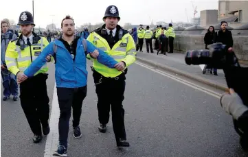  ??  ?? Police detain a protester as climate change activists demonstrat­e during a Extinction Rebellion protest at the Waterloo Bridge in London. — Reuters photo