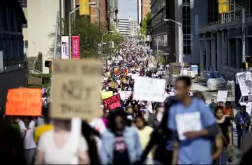  ?? David Goldman/Associated Press ?? Demonstrat­ors march Saturday through downtown Baltimore, the day after charges were announced against six police officers involved in the death of Freddie Gray.