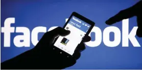  ?? - File photo ?? CONTROVERS­Y: A smartphone user shows the Facebook applicatio­n, in this photo illustrati­on taken May 2, 2013. Ahead of the June 8 parliament­ary election in Britain, it urged its users in the country to be sceptical of headlines that look unbelievab­le...