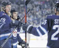  ?? CP PHOTO ?? Winnipeg Jets’ Patrik Laine, left, celebrates his goal with teammates Nikolaj Ehlers, centre, and Paul Stastny during NHL action Friday night against the Detroit Red Wings in Winnipeg.