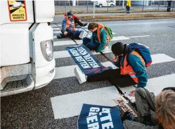  ?? Foto: Matthias Balk, dpa ?? Klima-aktivisten haben sich auf einer Straße festgekleb­t und behindern den Verkehr.