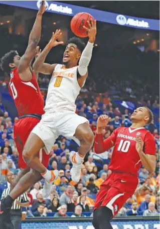  ?? THE ASSOCIATED PRESS ?? Tennessee’s Jordan Bone, center, drives to the basket between Arkansas’ Jaylen Barford, left, and Daniel Gafford during the first half of their SEC tournament semifinal Saturday in St. Louis. Bone scored 19 points to lead the 13th-ranked and...