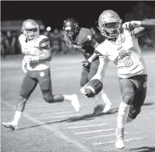  ??  ?? Notre Dame’s Justyn Baker tries to stay in bounds after an intercepti­on against Silverdale.