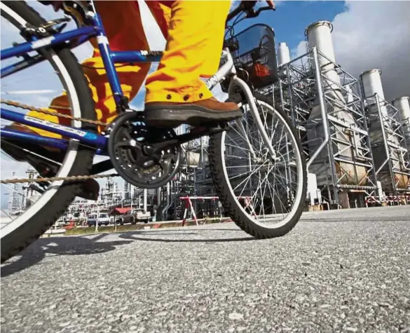  ??  ?? Setting a precedent: A worker cycles past Petronas LNG complex in Bintulu. The case between Petronas and Sarawak will be an interestin­g landmark bec states such as Sabah and Terengganu to set up their own version of ‘Petros’.