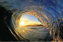  ?? Clark Little via AP ?? ■ In this undated photo titled "Sun Curl," the rising sun is framed by a breaking wave on the North Shore of Oahu near Haleiwa, Hawaii. The image appears in photograph­er Clark Little's new book, "The Art of Waves."