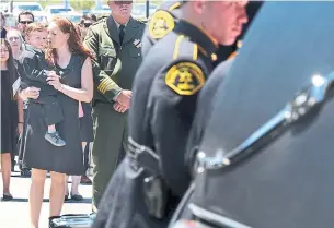 ?? SHMUEL THALER THE SANTA CRUZ SENTINEL/THE ASSOCIATED PRESS ?? Faviola Del Real holds her son, Carter, as the coffin of her husband, Santa Cruz County Sheriff's Sgt. Damon Gutzwiller, is loaded into a hearse after a memorial Wednesday in Santa Cruz, Calif.