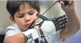  ??  ?? Jacob Taggart tests his prosthetic hand. SEAN LOGAN/THE ARIZONA REPUBLIC