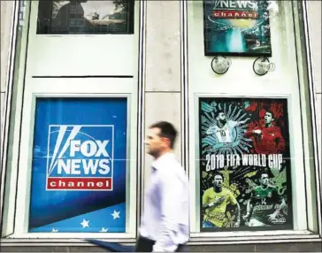  ?? GETTY IMAGES/AFP SPENCER PLATT/ ?? A man walks by the headquarte­rs of 21st Century Fox on Wednesday in New York City. Comcast, the giant cable operator, on Wednesday officially made a $65 billion all-cash bid for the majority of Fox.