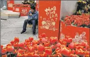  ?? AP/NG HAN GUAN ?? A man uses his smartphone Saturday at a popular retail district in Beijing.