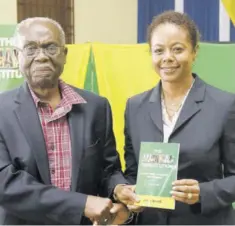  ?? ?? Minister of Legal and Constituti­onal Affairs Marlene Malahoo Forte accepts a copy of Dr Lloyd Barnett’s new book on the constituti­on from the author at the launch last Thursday.