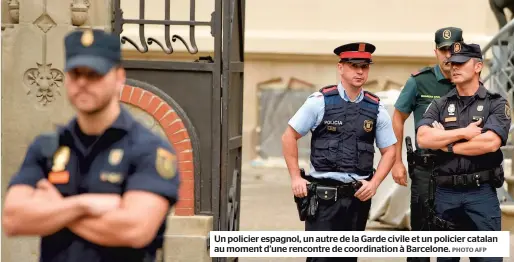  ?? PHOTO AFP ?? Un policier espagnol, un autre de la Garde civile et un policier catalan au moment d’une rencontre de coordinati­on à Barcelone.