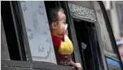  ?? Reuters ?? A girl protects her mouth with tissue looks through the window of a bus in Cairo.