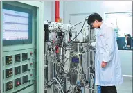  ??  ?? A technician performs experiment­s at a lab of a biotechnol­ogy company in Zhangjiang.