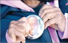  ?? ?? Annie Polite puts on a button for Ahmaud Arbery outside the Glynn County Courthouse as the jury deliberate­s in the trial of the killers of Arbery. — AFP file photos