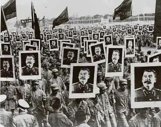  ?? ?? Des communiste­s chinois portent des affiches avec des photos de Joseph Staline, le leader communiste. Ils célèbrent le premier anniversai­re du régime communiste en Chine en 1951.