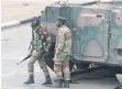  ??  ?? Soldiers stand by near President Robert Mugabe’s office in Harare yesterday.