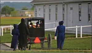  ?? (File Photo/AP/Jessie Wardarski) ?? Families of the Old Order Stauffer Mennonite Church in New Holland, Pa., arrive in May by horsedrawn buggy for their first in-person church service in nearly two months due to the coronaviru­s.