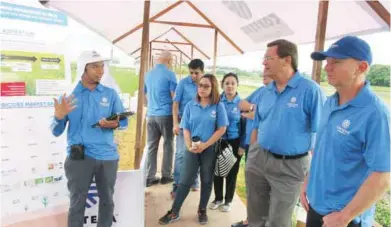  ??  ?? Collins (second from right) listens to Christian Mallari as he explains the EduFarm set up.