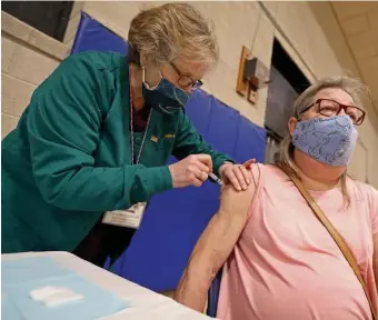  ?? MATT STONE / HERALD STAFF FILE ?? WELCOME SHOTS: Nurse Carrie MacDonald gives Joanne Faust of Easton a coronaviru­s vaccinatio­n at Cape Cod Commnity College in Barnstable.